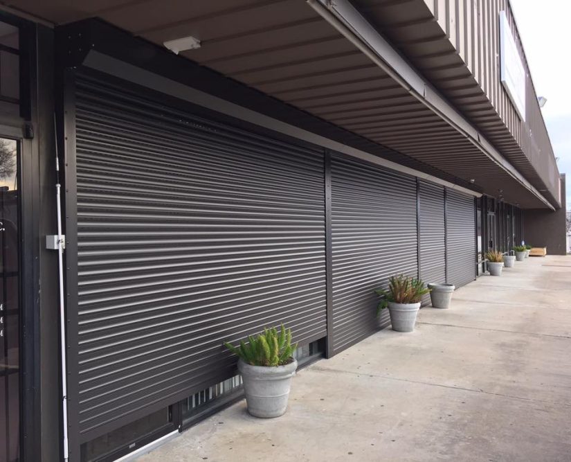 Dark bronze rolling shutters on a store front.
