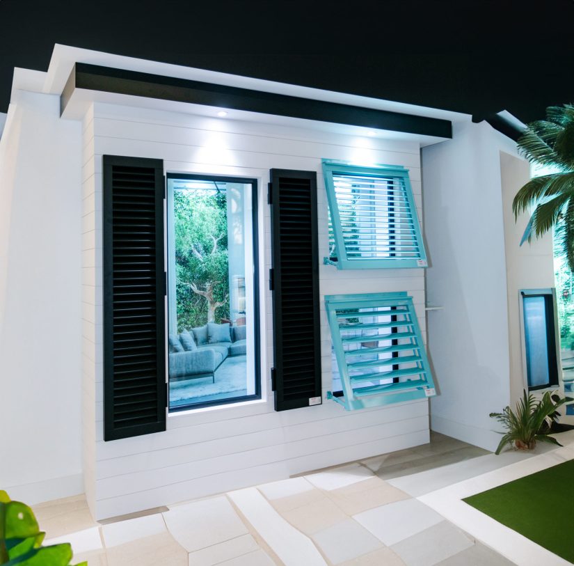 House with black Colonial shutters and blue Bahama shutters