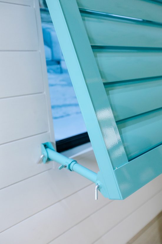 Close-up of a powder blue Croci Bahama shutter, featuring adjustable louvers and a smooth finish.
