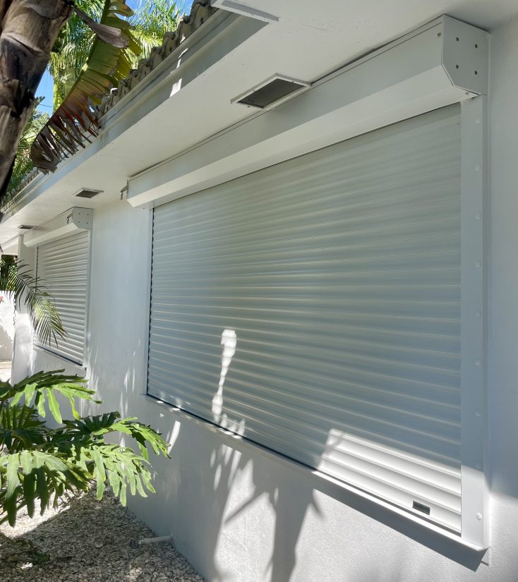 White hurricane rolling shutter covering a homes windows.